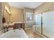 Bright bathroom features a shower, tub and vanity with ample lighting at 12839 W Rincon Ct, Sun City West, AZ 85375