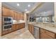 A modern kitchen with stainless steel appliances, tile flooring, and granite countertops, creating a welcoming atmosphere at 12839 W Rincon Ct, Sun City West, AZ 85375