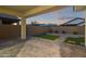Inviting backyard features a covered patio, pavers, artificial turf, and desert landscaping at 14372 W Aster Dr, Surprise, AZ 85379