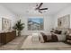 Bright bedroom with plush carpet, a ceiling fan, and a large window providing ample natural light at 14372 W Aster Dr, Surprise, AZ 85379