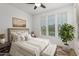 Comfortable bedroom features three windows, neutral tones, and a ceiling fan for a relaxing atmosphere at 14372 W Aster Dr, Surprise, AZ 85379