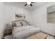 Cozy bedroom with light wood furniture, a soft rug, and a ceiling fan, providing a peaceful retreat at 14372 W Aster Dr, Surprise, AZ 85379
