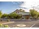 Exterior view of the community building featuring ample parking, mature landscaping, and classic architectural design at 14372 W Aster Dr, Surprise, AZ 85379