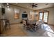 Spacious dining area with a long wooden table, seating for eight, light wood floors, and a TV, ideal for casual meals at 14372 W Aster Dr, Surprise, AZ 85379