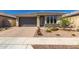 Attractive single-story home with a two-car garage, brick driveway, and desert landscaping for easy maintenance at 14372 W Aster Dr, Surprise, AZ 85379