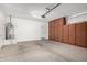 Garage with built-in storage cabinets, water heater, and access door at 14372 W Aster Dr, Surprise, AZ 85379