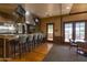 A kitchen area with a granite bar, stainless steel appliances, seating, and a view to a gathering spot near an outdoor patio at 14372 W Aster Dr, Surprise, AZ 85379