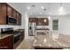 Well-equipped kitchen features a center island, stainless steel appliances, granite counters, and ample cabinet space at 14372 W Aster Dr, Surprise, AZ 85379