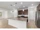 Bright kitchen with a large center island, granite countertops, stainless steel appliances, and pendant lighting at 14372 W Aster Dr, Surprise, AZ 85379