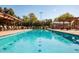 Community pool featuring crystal-clear water and lounge seating near grassy areas at 14372 W Aster Dr, Surprise, AZ 85379