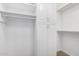 Walk-in closet with built-in white shelving and storage cabinets at 14372 W Aster Dr, Surprise, AZ 85379