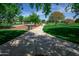 Scenic walking path through community park with mature trees and seating areas at 14372 W Aster Dr, Surprise, AZ 85379