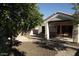 Covered patio extends to backyard with lush trees and desert rock landscaping at 14462 N Sherwood Dr # B, Fountain Hills, AZ 85268