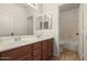 Bathroom featuring a double sink vanity with a large mirror and neutral tile floors at 16510 W Baden Ave, Goodyear, AZ 85338