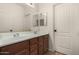 Bathroom featuring a double sink vanity with a large mirror and neutral tile floors at 16510 W Baden Ave, Goodyear, AZ 85338