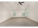 Spacious carpeted bedroom featuring a modern ceiling fan and multiple windows offering ample natural light at 16510 W Baden Ave, Goodyear, AZ 85338