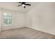A bright bedroom with neutral carpet, a ceiling fan and a window allowing natural light at 16510 W Baden Ave, Goodyear, AZ 85338