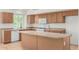 Traditional kitchen featuring wood cabinets, white appliances, and a convenient center island for meal prep at 16510 W Baden Ave, Goodyear, AZ 85338