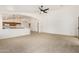Large, carpeted living room with an open floor plan flows into the adjacent kitchen and dining area at 16510 W Baden Ave, Goodyear, AZ 85338