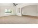 Open living space with ample light, neutral carpet, and arched doorways to adjacent rooms at 16510 W Baden Ave, Goodyear, AZ 85338