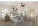 Cozy main bedroom with neutral tones, soft carpet, ceiling fan, and ensuite bathroom entrance at 16510 W Baden Ave, Goodyear, AZ 85338