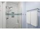 Updated shower with white subway tile, decorative blue accent band, glass doors, and updated shower fixtures at 16801 N 94Th St # 2005, Scottsdale, AZ 85260