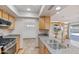 Kitchen with granite countertops, wood cabinets, and stainless appliances open to the living area at 16824 N 38Th Dr, Phoenix, AZ 85053