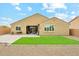 A landscaped backyard featuring a covered patio, artificial turf, and desert landscaping at 18438 W Brookwood Dr, Goodyear, AZ 85338