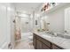 Well-lit bathroom featuring a granite countertop, tiled shower-tub, and neutral tiling throughout at 18438 W Brookwood Dr, Goodyear, AZ 85338