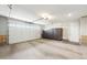 Bright, clean garage with storage cabinets, epoxy floor, and a roll up overhead door at 18438 W Brookwood Dr, Goodyear, AZ 85338