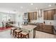 Modern kitchen featuring an island with counter seating, stainless steel appliances, and a dining area bathed in natural light at 18438 W Brookwood Dr, Goodyear, AZ 85338