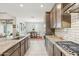 Bright kitchen featuring stainless appliances, granite countertops and gray cabinetry with a view into the dining room at 18438 W Brookwood Dr, Goodyear, AZ 85338