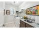 Functional laundry room with sink, countertop, shelving, and framed art providing both utility and decorative touch at 18438 W Brookwood Dr, Goodyear, AZ 85338