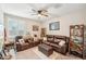 Cozy living room with plush leather seating, ceiling fan, and natural light, creating a comfortable space to unwind at 18438 W Brookwood Dr, Goodyear, AZ 85338