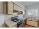 Kitchen featuring wood cabinets, black appliances and a stainless steel sink under a window at 1935 W Morten Ave # 17, Phoenix, AZ 85021