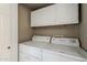 Well-equipped laundry room with washer, dryer, and built-in cabinets for convenient storage at 1935 W Morten Ave # 17, Phoenix, AZ 85021