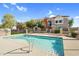 Inviting community pool with surrounding fence, landscaping, and multi-story townhomes at 1950 N Center St # 101, Mesa, AZ 85201