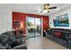 Spacious living room with tile flooring, ceiling fan, patio access, and TV at 1950 N Center St # 101, Mesa, AZ 85201