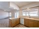 Open-concept kitchen with wooden cabinets, a white dishwasher, and laminate flooring at 20327 N 110Th Dr, Sun City, AZ 85373