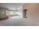 Bright living room featuring neutral carpet, lots of light, and an archway entrance at 20327 N 110Th Dr, Sun City, AZ 85373