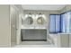 Bathroom featuring a double vanity with large mirrors, updated lighting, and a shower/bath at 20802 N 74Th Ln, Glendale, AZ 85308