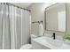 Updated bathroom featuring a marble vanity, modern fixtures, and a patterned shower curtain at 20802 N 74Th Ln, Glendale, AZ 85308