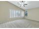 Large bedroom with neutral carpet, a ceiling fan, vaulted ceilings, and a large window at 20802 N 74Th Ln, Glendale, AZ 85308