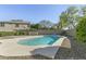Backyard featuring a sparkling pool, view of the home's exterior, privacy wall, and well-manicured landscaping at 20802 N 74Th Ln, Glendale, AZ 85308