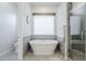 Bathroom showcasing a standalone tub, tiled walls, and a glass-enclosed shower at 20961 E Stacey Rd, Queen Creek, AZ 85142