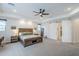 Spacious main bedroom featuring a tray ceiling, ceiling fan, and sliding barn door at 20961 E Stacey Rd, Queen Creek, AZ 85142