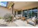 Relaxing covered patio featuring comfortable seating, neutral tones and smooth concrete flooring at 20961 E Stacey Rd, Queen Creek, AZ 85142