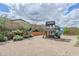 Backyard featuring a playhouse with slide surrounded by desert landscaping at 20961 E Stacey Rd, Queen Creek, AZ 85142