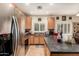 Bright kitchen with wood cabinets, stainless steel refrigerator, island counter and ample natural light from the window at 21752 E Domingo Rd, Queen Creek, AZ 85142