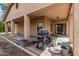 Covered patio area featuring an outdoor grill with seating and a tan stucco exterior at 21752 E Domingo Rd, Queen Creek, AZ 85142